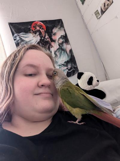 Alisha with her parrot on her shoulder